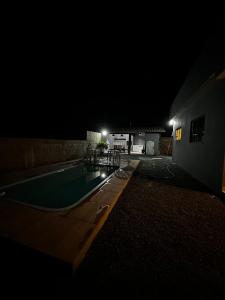 a swimming pool at night with a building at Rancho Ameixeira in Paty do Alferes