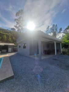 a house with the sun shining on top of it at Rancho Ameixeira in Paty do Alferes