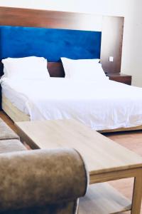 1 dormitorio con 2 camas, mesa y silla en Safa PARK HOTEL YANBU فندق صفا بارك ينبع, en Yanbu