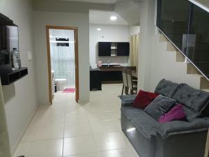 sala de estar con sofá y cocina en Sobrado familiar, en São Francisco do Sul