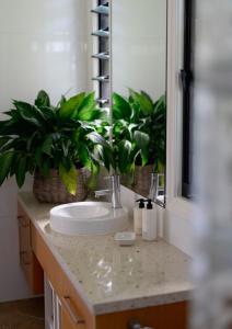 a bathroom with a sink and two potted plants at The Outlook Cabana in Terrigal