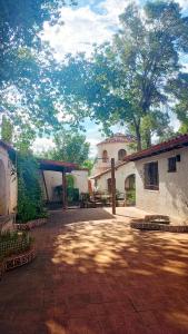 a patio with a building and trees in the background at El Torreón Lodge in Potrerillos