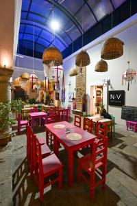 a dining room with red tables and red chairs at CASA FORTALEZA in Oaxaca City
