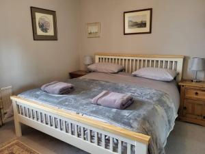 une chambre avec un grand lit avec deux oreillers dans l'établissement Homely 4 bed cottage central characterful, à Pateley Bridge