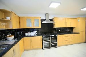 una cucina con armadi gialli e ripiani neri di Impeccable 3 bedroom house a Plumstead