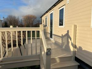 um deque de madeira com um corrimão numa casa em Seton Sands Muirfield 6 em Port Seton