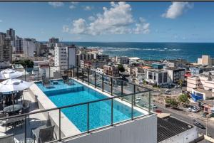 uitzicht op een zwembad op het balkon van een gebouw bij Apartamento 1/4 in Salvador