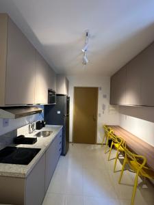 een keuken met witte kasten en gele stoelen. bij Apartamento 1/4 in Salvador