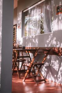 una mesa de madera y sillas en una habitación en La Serena Hostel, en Pipa