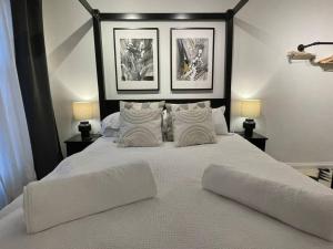 a bedroom with a large white bed with two lamps at Ultra Modern Studio Apartment, in Central Exeter in Exeter