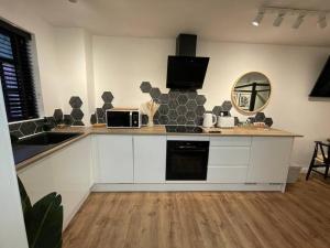 een keuken met een aanrecht met een wastafel en een magnetron bij Ultra Modern Studio Apartment, in Central Exeter in Exeter