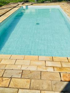 uma piscina com água azul e um piso de madeira em linda chácara com casa principal pomar & piscina em Serra Negra