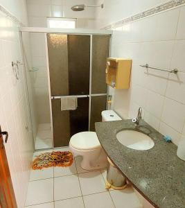 Un baño con inodoro, lavabo y ducha. en Condominio Sol Poente, en Salinópolis 7 fotos más