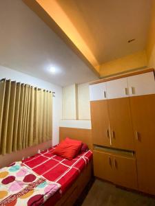 een slaapkamer met een bed en een dressoir bij The Suites Metro by KS Property in Bandung