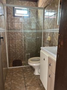 a bathroom with a shower and a toilet and a sink at Casas Verão Bombinhas in Bombinhas +29 photos