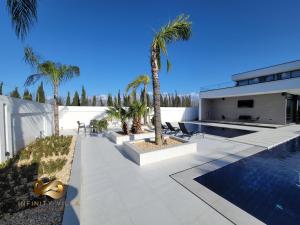 eine Villa mit einem Pool und Palmen in der Unterkunft Infinity Villa in Rrushkull