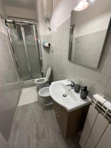 a bathroom with a toilet and a sink and a shower at Aparthouse Torri in Trieste