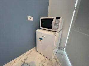 a microwave sitting on top of a refrigerator at Remar Suítes 01 - Melhor localização do Guarujá e perto da praia! in Guarujá