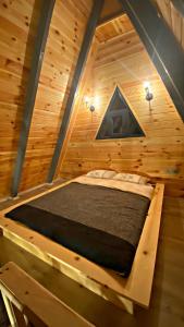 a bed in the middle of a wooden room at Zua Bungalow in Pazar