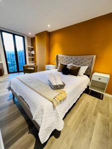 a bedroom with a large bed with a yellow wall at Apartamento Airali in Guatemala