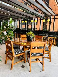 una mesa de madera y sillas en un restaurante en Apartamento 2 Habitaciones, Edificio Airali, Zona 10, Miradolo, en Guatemala