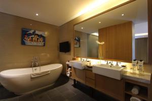a bathroom with two sinks and a large mirror at Ossotel Legian in Legian