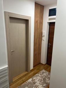 een kamer met een deur en een hal met een tapijt bij Paulina Apartments in Čačak