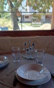a table with a white plate and glasses on it at Departamento Anita in El Hoyo