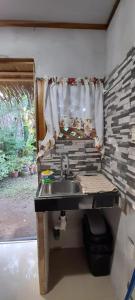 a kitchen with a sink and a window with at Casa Tauchin in Puerto Viejo