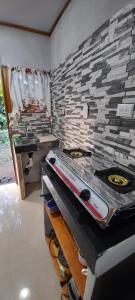 a kitchen with a stove and a stone wall at Casa Tauchin in Puerto Viejo