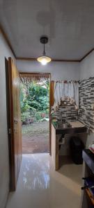 Zimmer mit einer Küche mit einem Tisch und einem Fenster in der Unterkunft Casa Tauchin in Puerto Viejo