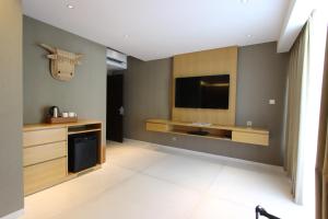 a living room with a flat screen tv on a wall at Ossotel Legian in Legian