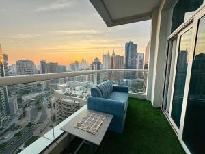a balcony with a blue chair and a table at 2 Bedroom Apartment near Atana in Dubai