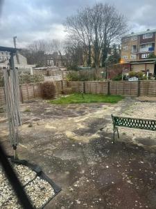 a park bench in a yard with a fence at La Vera in South Norwood