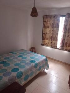 - une chambre avec un lit et une fenêtre avec un rideau dans l'établissement Casa en Punta del Diablo, à Punta del Diablo
