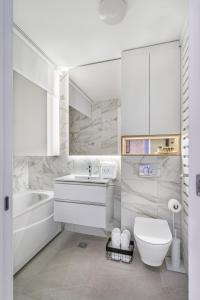 a white bathroom with a toilet and a sink at Melody Apartment in Novi Beograd