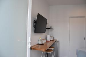 a room with a counter with a tv on a wall at Peninsula Beachside Accommodation in Capel Sound