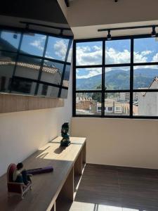 een persoon op een bankje in een kamer met ramen bij Hermoso apartamento en Pamplona in Pamplona