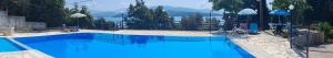 a large blue swimming pool with mountains in the background at Kerasia Villas - 4 apartments & cottage in (( Kerasá ))