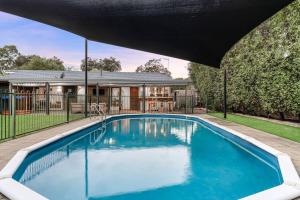 - une piscine dans l'arrière-cour d'une maison dans l'établissement Shine Carrum Down - Family Oasis In A Tranquil Court, à Carrum Downs