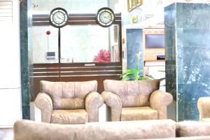 eine Lobby mit zwei Stühlen und einer Uhr an der Wand in der Unterkunft Safa PARK HOTEL YANBU فندق صفا بارك ينبع in Yanbu
