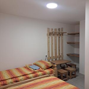 a bedroom with two beds and a table and shelves at STD "Vila Bor" Stara planina in Crni Vrh