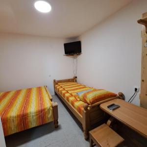 a room with two beds and a table and a tv at STD "Vila Bor" Stara planina in Crni Vrh