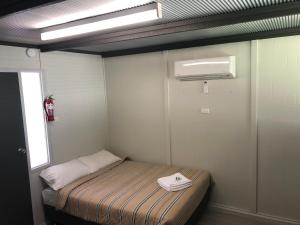 KanyapellaにあるRiver Bend Caravan Parkのベッド1台、エアコンが備わる小さな客室です。