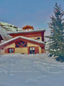 a house in the snow with a christmas tree at Chalet Barbara in Livigno