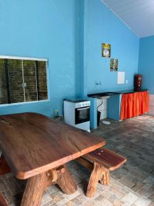 a large wooden table in a room with a window at Casadabiquinha in Pirenópolis