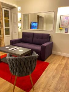 a living room with a purple couch and a table at Apartamentos Colmeia in Lisbon