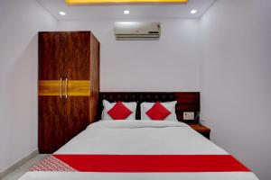 a bedroom with a white bed with red pillows at Oxygen in Rānchī