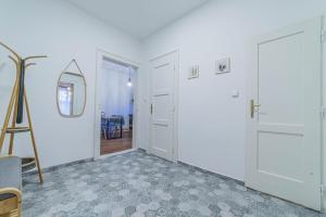 a hallway with two white doors and a mirror at Apartmán náměstí Karviná in Karviná