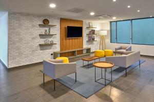 a lobby with chairs and a tv and a table at City Express by Marriott Tampico Altamira in Tampico